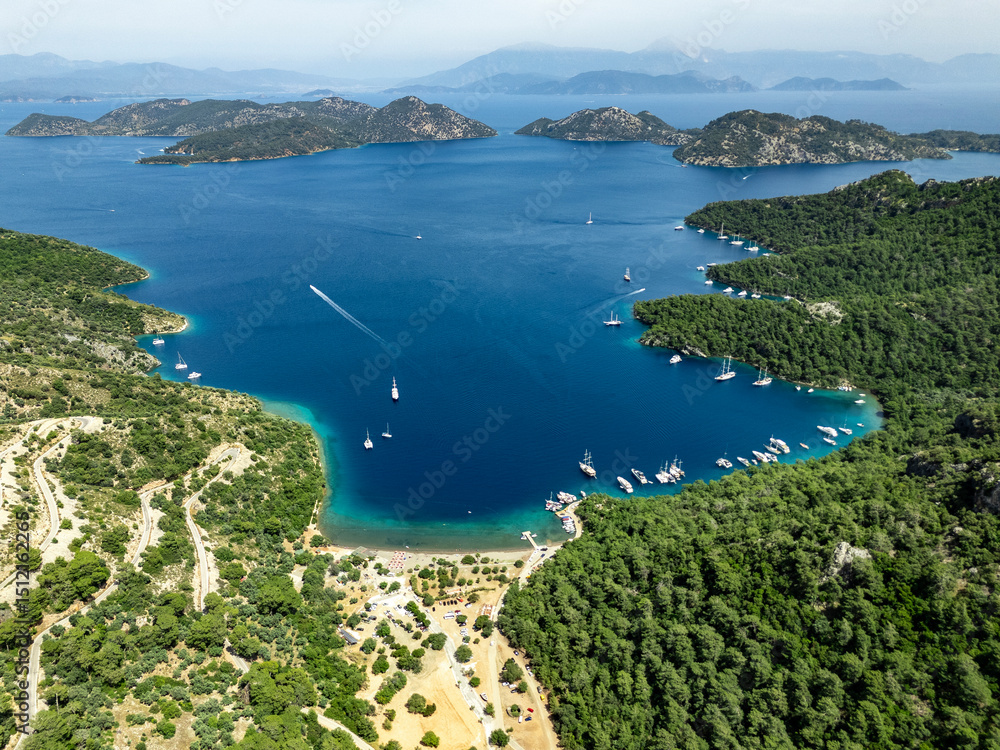 Obraz premium Sailing boats navigating the turquoise waters of Sarsala Bay in Dalaman, Turkey