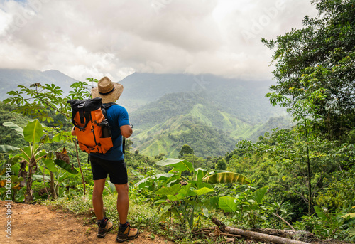 hiker in the mountains of sierra nevada of santa marta jungle in colombia with big backpack and hat 