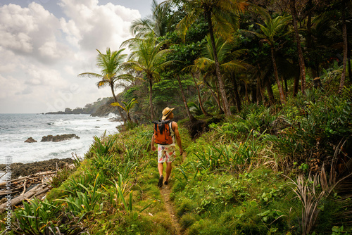 Male traveler walking in the tropical rainforest on the shores of the Caribbean Sea in Capurgana, Chocó, Colombia. Travel destination
