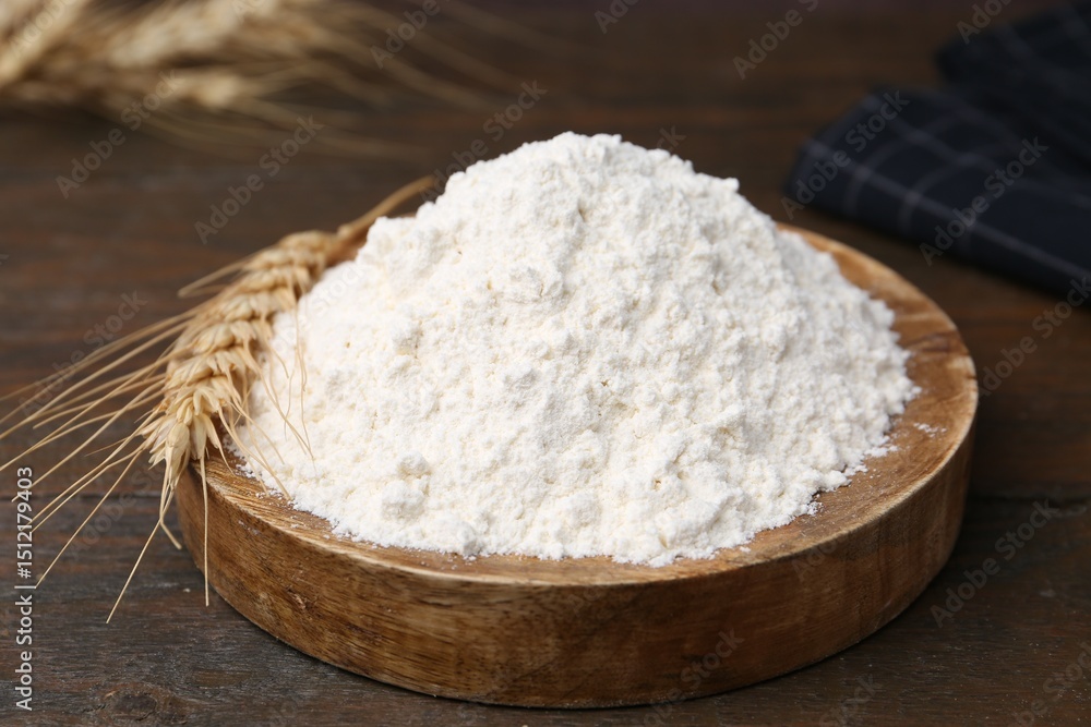 Wheat flour and spikes on wooden table, closeup Wheat flour and spikes on wooden table, closeup