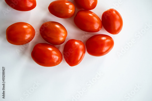 Foto Top view of ripe red cherry tomatoes arranged on a white surface