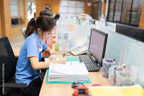 The female employee stayed late to complete an important business proposal, working tirelessly at her computer to finalize the document before tomorrow’s early morning meeting.