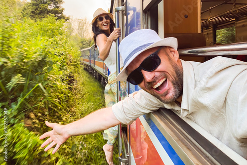 Happy excited passenger travel couple stand by doorstep enjoy popular train ride journey Kandy to Ella and admire Sri lanka lush jungle landscapes. Embrace freedom, curiosity, wonder asia travel
