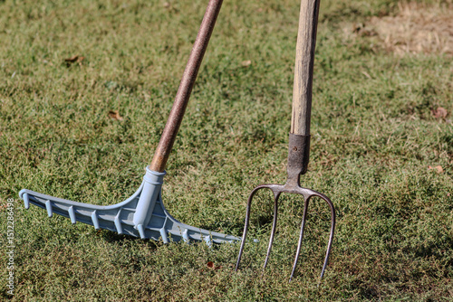 Papier peint A rake and a pitchfork lie on the grass, showcasing essential tools used for gat