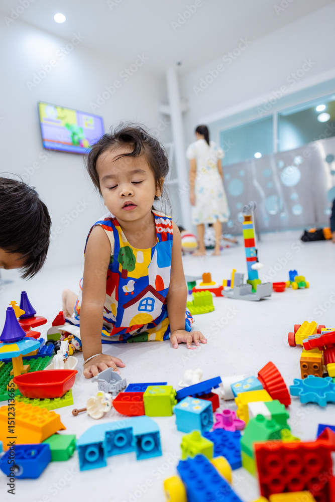 Naklejka premium Kindergarten kids boy and girl enjoy toy block building