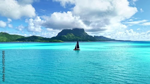 Drone aerial Tahiti. Aerial view of Bora Bora turquoise crystal clear water lagoon, tour sail boat. French Polynesia 4k.  Luxury honeymoon vacation, romantic getaway, exotic resort destination. 