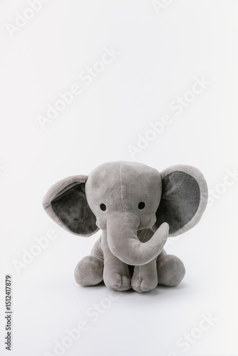 Baby elephant stuffed animal sitting on a white background
