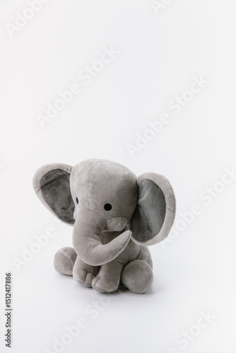 Baby elephant stuffed animal sitting on a white background