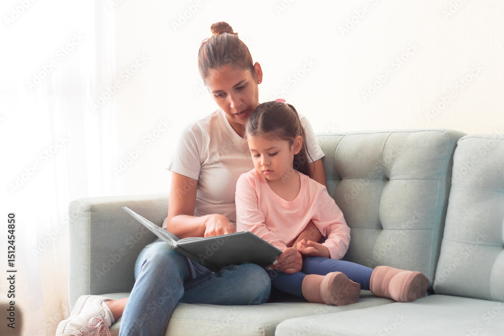Madre joven leyendo un cuento a su hija fomentando la lectura y desarrollando la imaginación. Madre joven leyendo un cuento a su hija fomentando la lectura y desarrollando la imaginación.