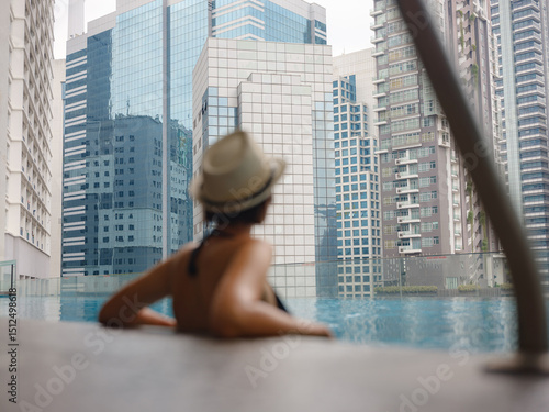 Photography Young woman relaxing by the pool at a Kuala Lumpur hotel