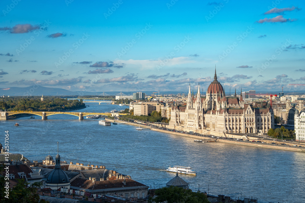Obraz premium The Majestic Hungarian Parliament Rises from the Danube's Embrace, Framed by a Canvas of Water and Sky