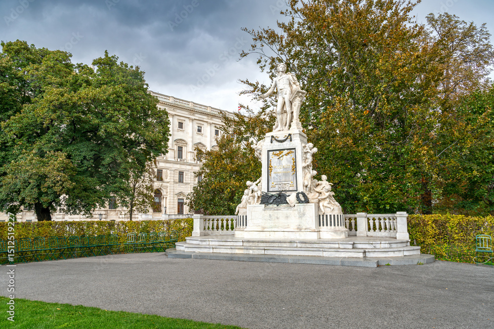 Obraz premium The Monument of Mozart in Vienna, Austria, honoring the legendary composer with its striking statue surrounded by lush greenery and the elegant design of the city park