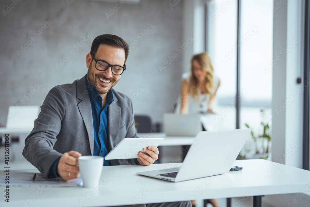 Obraz premium Professional Businessman Smiling While Using Tablet in Modern Office