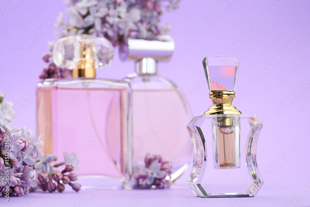 Bottles with perfumes and lilac flowers on violet background, selective focus Bottles with perfumes and lilac flowers on violet background, selective focus