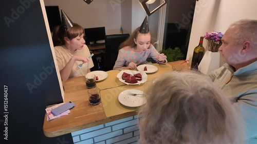 Three generations of a happy family — grandmother, grandfather, mother, and daughter — celebrating the little girl’s birthday together at home, enjoying a warm and joyful moment.