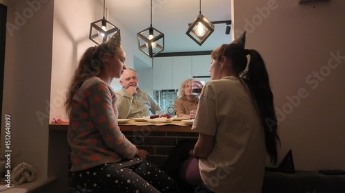 Three generations of a happy family — grandmother, grandfather, mother, and daughter — celebrating the little girl’s birthday together at home, enjoying a warm and joyful moment.