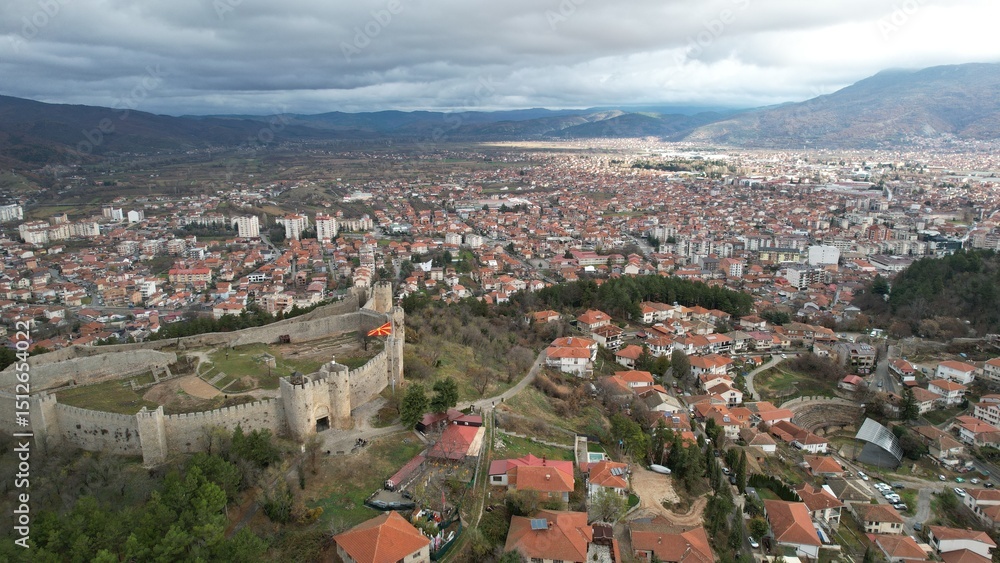 Obraz premium Historic Samuel's fortress overlooks serene coastal town with modern architecture under cloudy sky, Ohrid 