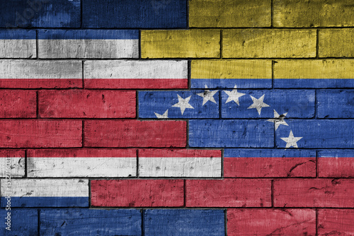colourful painted big national flag of venezuela and flag of costa rica on a massive old brick wall background. concept