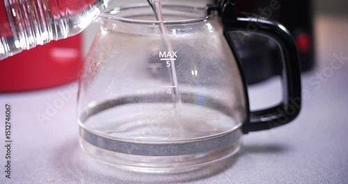 pouring water into coffee pot