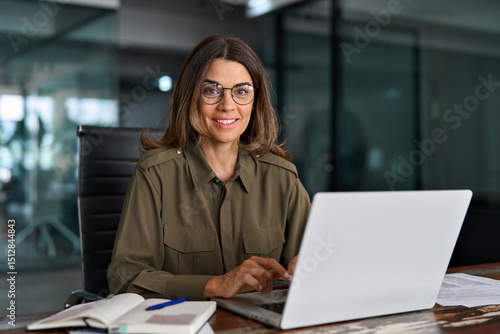 Papier peint Happy mature middle aged professional business woman investor working on laptop computer in office, portrait