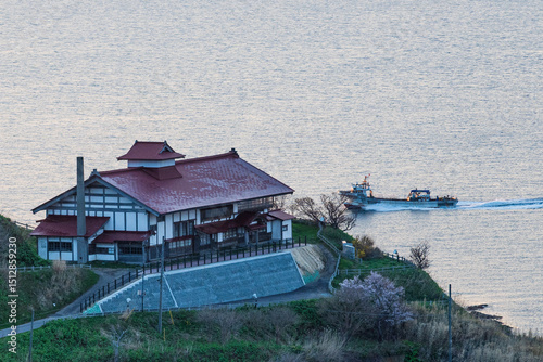 漁船が行く海を見下ろす岬の鰊御殿