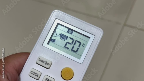 Hand Holding Remote Displaying 20 celcius
Description: Close-up of a hand holding a remote control showing 20 celcius on the display; appliance control and user interaction concept.