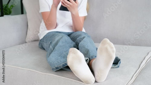 The child has dirty socks. The girl uses a mobile phone
