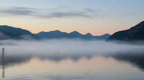Wallpaper Mural Serene sunrise over misty lake with mountains in the background reflecting calm waters Torontodigital.ca