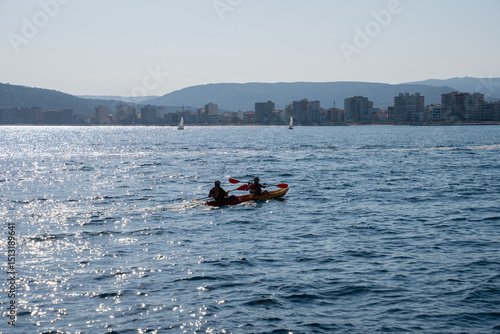 Two people kayaking on the sea on a sunny day