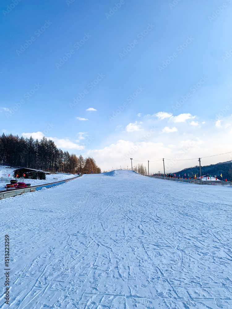 Fototapeta premium Winter and outdoor fun snowy activities, ski, tube slide, snow mobile, banana boat ride at Snow Valley, China 