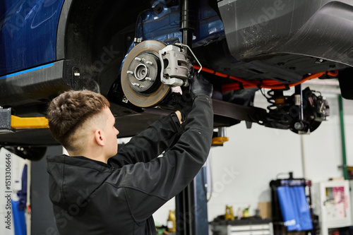 The master works with the brake system and suspension of the car at the service.