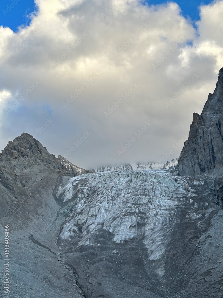 Obraz premium A glacier in the mountains. Aksai, Kyrgyzstan, Ala Archa National Park. Melting glaciers, disappearing glaciers, global warming, Switzerland, Tien Shan. Ice covered with grey dust