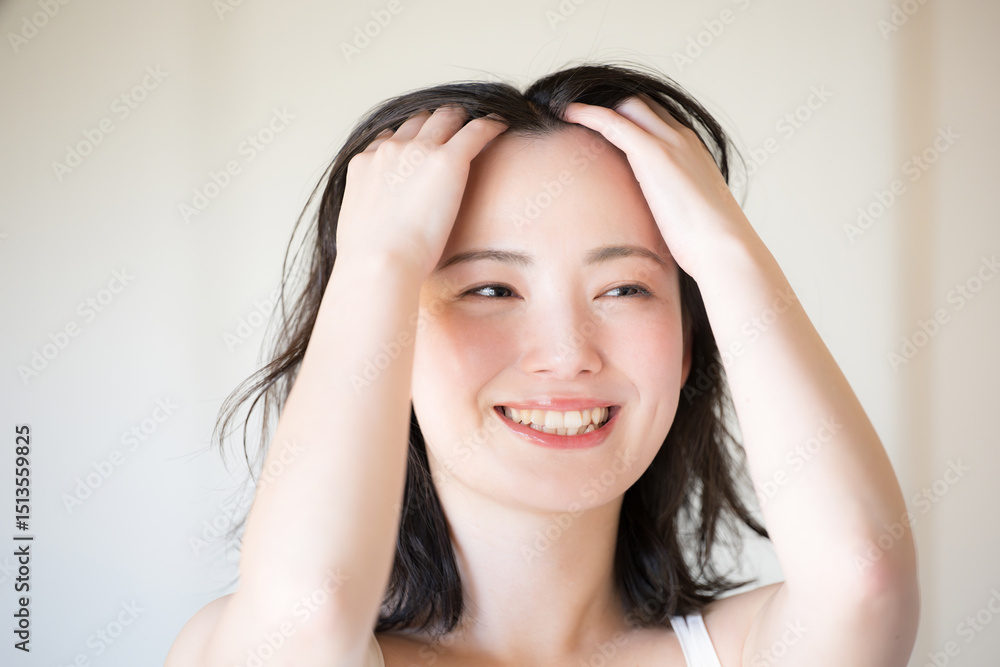 Fototapeta premium ヘアケアをする美しい女性のビューティーイメージ クローズアップの正面 黒髪のミディアムヘア