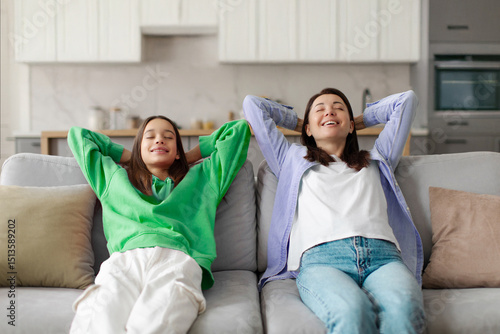 Принти на полотні Calm and relaxed mom and teenage daughter chilling on couch hands over head, res