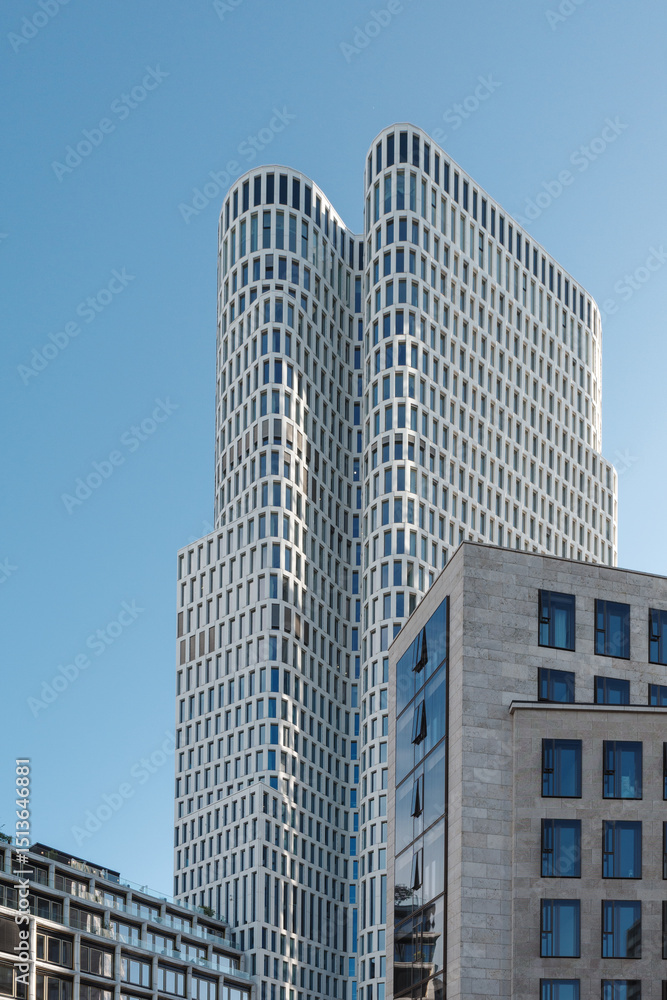 Obraz premium Low angle exterior view of the modern white curved Upper West tower and office buildings against a clear blue sky near Zoologischer Garten in Berlin Germany. 