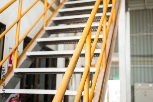 Konstfotografi Banister handrail with yellow painting of stairway platform at the factory place