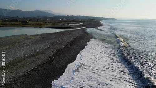Discover an enchanting landscape along the Adjara coastline in Georgia, where the vibrant river flows into the vast Black Sea, intricately shaping the shoreline.