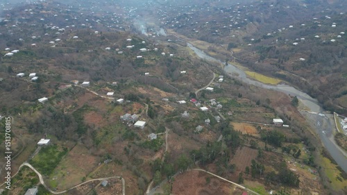 Explore the stunning landscape of Adjara, Georgia. This captivating aerial view reveals winding rivers, lush fields, and vibrant neighborhoods. Experience the natural beauty and tranquil environment.