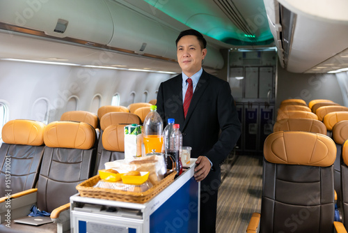 фотографія serving drinks : Portrait Stewardess holding water bottle in airplane cabin