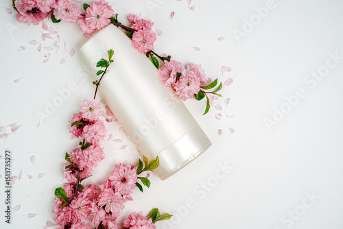Shampoo, hair conditioner in a white jar on a white background. Mockup, space for text. Sakura flowers. Shampoo for normal hair, nutrition and protection with flower extracts