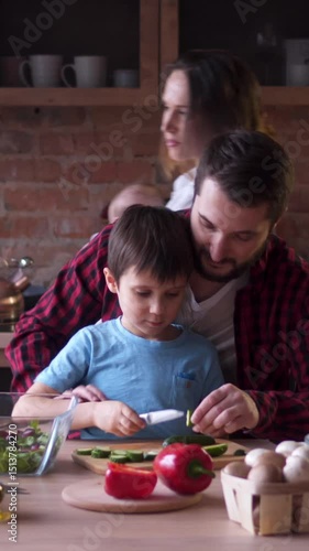 Friendly family cooking dinner together on the kitchen at home, collaborating in a household task with warmth and enjoyment. Vertical video.