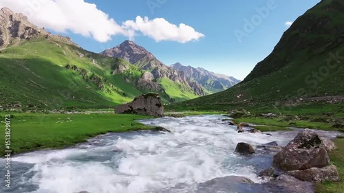 Mountain Stream in Village
Description: A mountain village with a stream running through green hills.