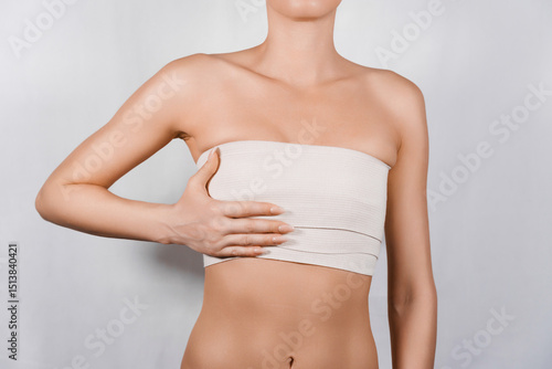 Unrecognizable Woman Showcases Her Chest with Elastic Bandage After Surgery for Congenital Anomaly Repair.