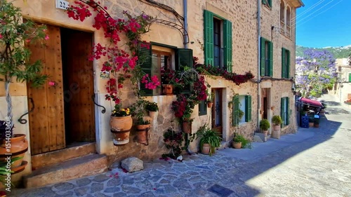 Valldemossa Mallorca floral street with traditional stone houses and flower pots decoration. Spain Balearic Islands picturesque village. Slow travel destination 