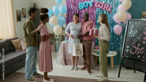 Wallpaper Mural Wide shot of smiling young Caucasian woman holding gift box speaking to pregnant female friend at gender reveal party, wishing happy motherhood, in living room with stylish blue and pink decorations Torontodigital.ca