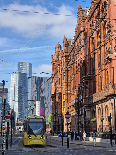 Yellow Tram Passing Historic Building and Modern Skyscrapers in Manchester, England