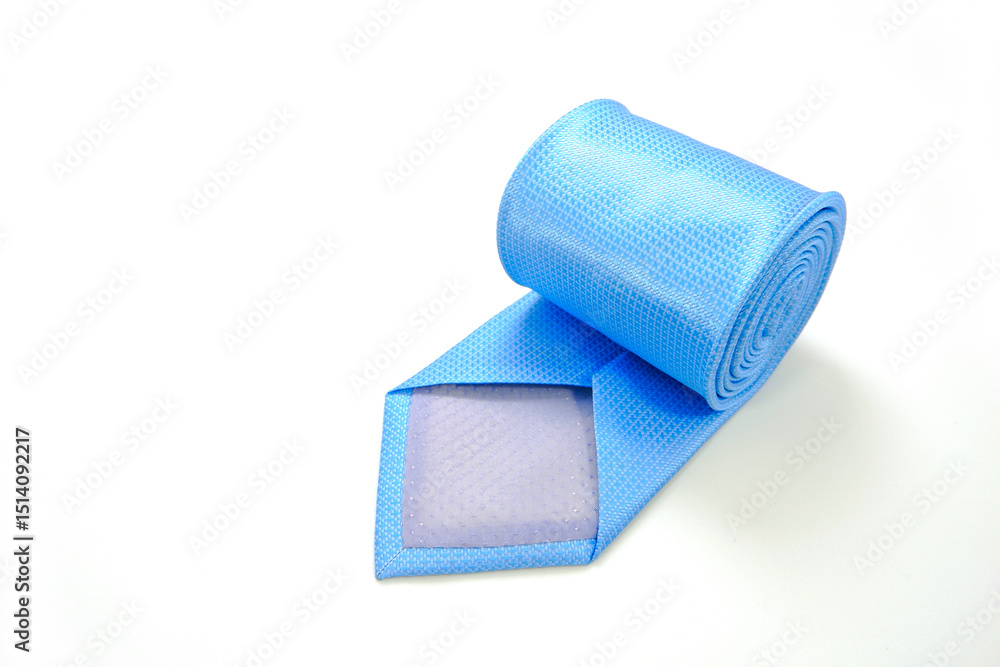 Fototapeta premium A blue tie rolled on white background closeup shot 