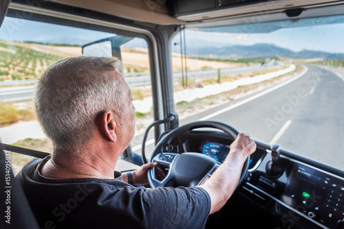 Aging truck driver behind the wheel, experienced but with slower reflexes, highlighting road safety issues.