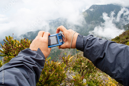 Man takes a photo of the landscape with his digital compact camera in El Picacho de Galipan El Avila Waraira Repano Caracas Venezuela.