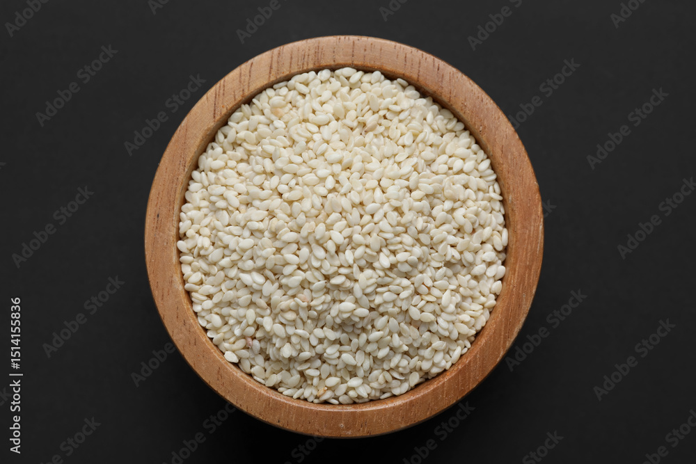 Sesame seeds in bowl on dark table, top view Sesame seeds in bowl on dark table, top view